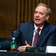 Microsoft President Brad Smith talks with his hands out on the table.